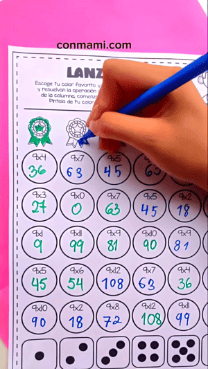 Niño pintando la medalla de su color al completar una columna de multiplicaciones